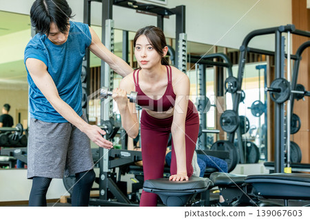 接受重量訓練指示的少婦在健身房 接受重量訓練指示的少婦在健身房 139067603