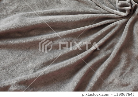 Taupe plush fleece fabric texture. Swirled folds of soft microfiber blanket. Taupe plush fleece fabric texture. Swirled folds of soft microfiber blanket. 139067645