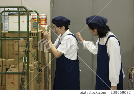 A colleague comforts a woman who is crying in the back room. 139069082