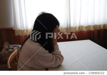 一名女子仍穿著家居服,頭髮蓬亂,無力地摀住臉。 一名女子仍穿著家居服,頭髮蓬亂,無力地摀住臉。 139069232