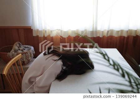 A woman, with her hair unkempt and still in her pajamas, slumped over listlessly. 139069244