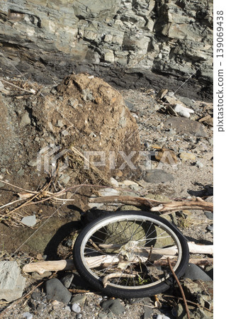 Rocky landscape with discarded bicycle wheel highlighting environmental pollution 139069438