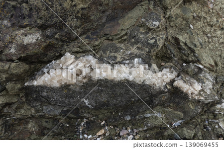 Crack in rock filled with quartz crystals Crack in rock filled with quartz crystals 139069455