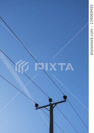 Electricity pylon and cables on blue sky vertical backdrop 139069493