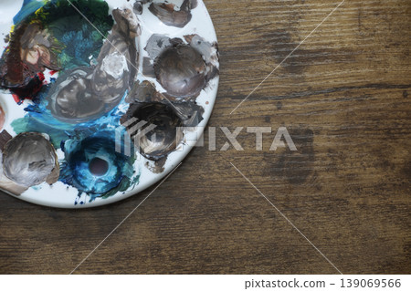 Dirty painter's palette with paint stains on wooden table Dirty painter's palette with paint stains on wooden table 139069566