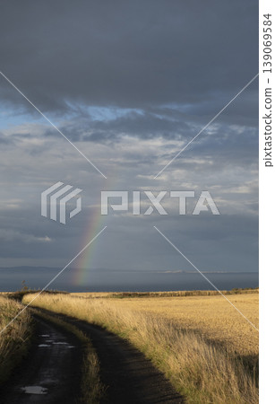Fall landscape with trail, distant mountains, sea and rainbow, vertical format Fall landscape with trail, distant mountains, sea and rainbow, vertical format 139069584