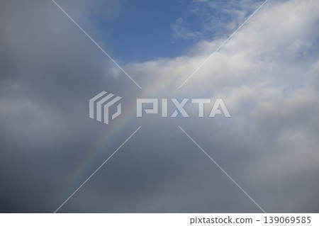 Dramatic cloudy sky with faint rainbow Dramatic cloudy sky with faint rainbow 139069585