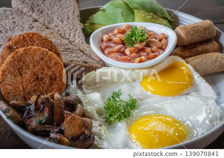 Traditional English breakfast with eggs, sausages, beans, hash browns and avocado. Traditional English breakfast with eggs, sausages, beans, hash browns and avocado. 139070841
