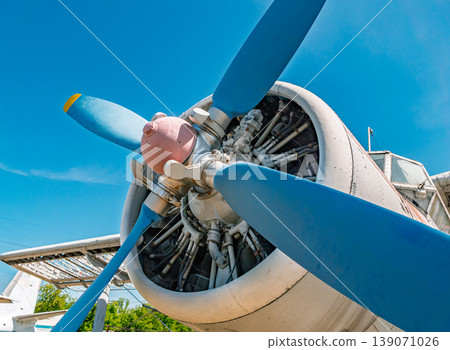 Detailed view of an old aircraft engine with bright blue propeller blades. Detailed view of an old aircraft engine with bright blue propeller blades. 139071026