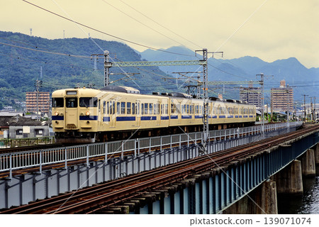 2007 年:一列 4 節車廂的 115 系列地方列車正在山陽本線上運行。 2007 年:一列 4 節車廂的 115 系列地方列車正在山陽本線上運行。 139071074