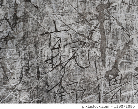 Aged concrete wall showing deep scratches and various carved characters creating an abstract pattern Aged concrete wall showing deep scratches and various carved characters creating an abstract pattern 139071090