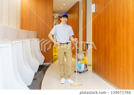 A young Japanese male cleaner wipes the floor of a restroom in an office building. Photo courtesy of Denpa Gakuen Tokyo Electronics College. A young Japanese male cleaner wipes the floor of a restroom in an office building. Photo courtesy of Denpa Gakuen Tokyo Electronics College. 139071768