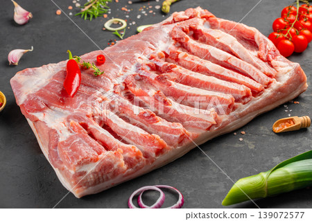 pork ribs raw rack sliced on board with spices garlic chili and herbs dark background copy space pork ribs raw rack sliced on board with spices garlic chili and herbs dark background copy space 139072577
