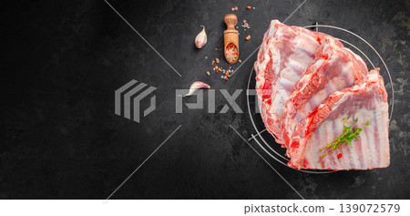 pork ribs raw rack on grill with garlic salt herbs dark background copy space 139072579