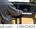 A man playing a grand piano 139072628
