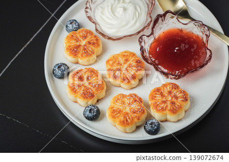 Cottage cheese pancakes, syrniki, curd fritters decorated with strawberry and raspberry served on a white plate. Homemade breakfast concept Cottage cheese pancakes, syrniki, curd fritters decorated with strawberry and raspberry served on a white plate. Homemade breakfast concept 139072674