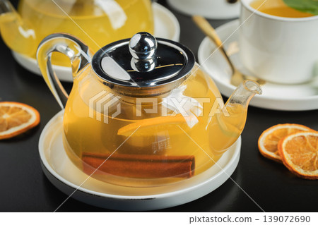 Fruit tea with mango and mint in a glass teapot on the table Fruit tea with mango and mint in a glass teapot on the table 139072690