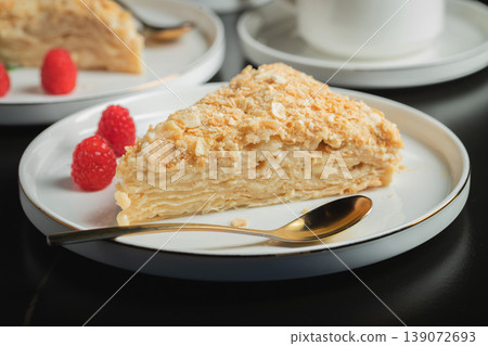 Sliced Napoleon cake on a white wooden table. Classic dessert 139072693