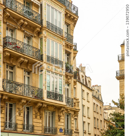 Ornate Parisian apartment buildings with balconies, architectural details, and stone facade, representing city life and travel in Paris, France 139072950