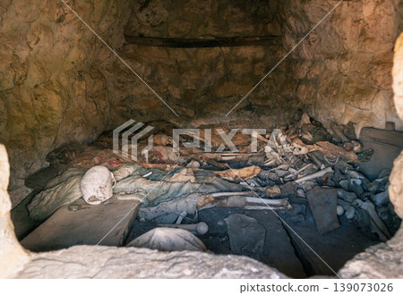 Interior view of an ancient Dargavs burial crypt, revealing human skeletal remains and deteriorated textiles Interior view of an ancient Dargavs burial crypt, revealing human skeletal remains and deteriorated textiles 139073026