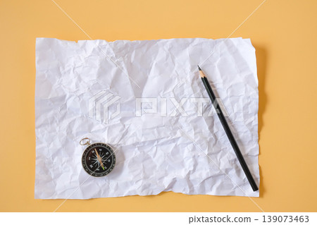 Crumpled white paper with vintage compass on color background. 139073463