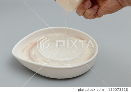 I'm grating yam using a ceramic grater. I'm grating yam using a ceramic grater. 139073518