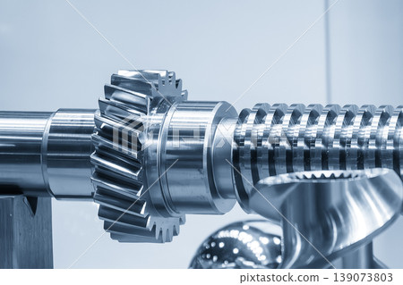 Close-up of a precision bevel gear mounted on a driving shaft for industrial power transmission. 139073803