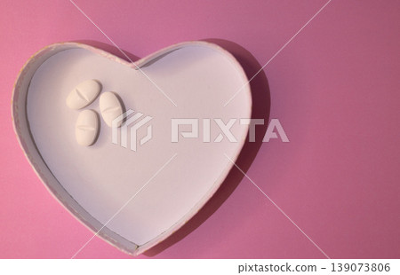 Top view or heart-shaped figure with white pills on one side Sapace for text. Top view or heart-shaped figure with white pills on one side Sapace for text. 139073806