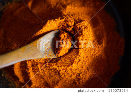 Very close up view of Paprika on a wooden spoon.Side light. 139073914