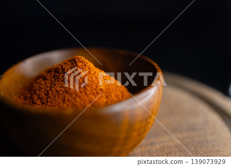 Very close up view of Red paprika powder on a wooden bowl Very close up view of Red paprika powder on a wooden bowl 139073929