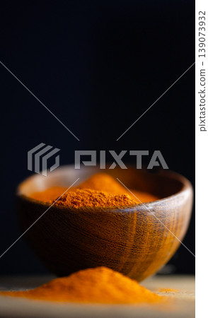 Vertical close up view of red paprika powder on a wooden bowl Vertical close up view of red paprika powder on a wooden bowl 139073932