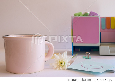 Modern workspace setup featuring a pink coffee mug, white flower, and pastel office organizer, symbolizing creative work-life balance and a personalized professional environment Modern workspace setup featuring a pink coffee mug, white flower, and pastel office organizer, symbolizing creative work-life balance and a personalized professional environment 139073949
