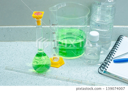 Laboratory instruments and solutions on a white countertop are prepared for chemical analysis, showcasing experimental procedures in a research and development setting 139074007