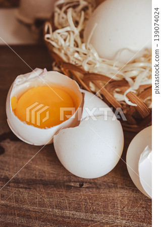 Fresh cracked egg with rich orange yolk revealing essential protein and vitamins. Fresh cracked egg with rich orange yolk revealing essential protein and vitamins. 139074024