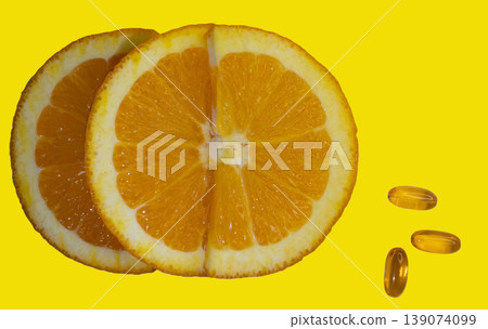 Shot from above of orange slice and Vitamin C capsules on yellow background. Shot from above of orange slice and Vitamin C capsules on yellow background. 139074099