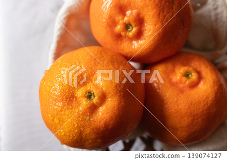 Top view of mandarins fruits with water drops in light background. 139074127