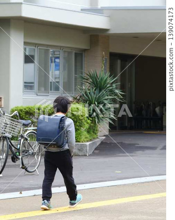 Elementary school students walking on a shoulder bag Elementary school students walking on a shoulder bag 139074173
