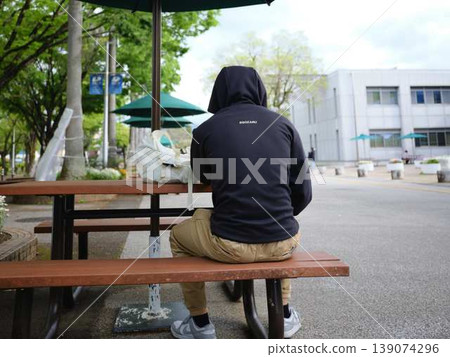 College student sitting on a bench College student sitting on a bench 139074296