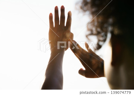 Woman using sunscreen lotion outdoors during sunset or sunrise. Focused view of hands spreading white cream against bright sky. Beauty and wellness themes, representing UV protection, hydration, and n Woman using sunscreen lotion outdoors during sunset or sunrise. Focused view of hands spreading white cream against bright sky. Beauty and wellness themes, representing UV protection, hydration, and n 139074779