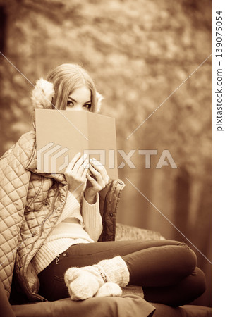 Blonde girl reading book in autumn scenery 139075054