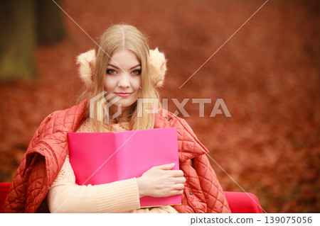 Blonde girl reading book in autumn scenery 139075056