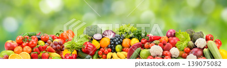 Bright Assortment of Fresh Fruits and Vegetables on Green Nature Background with Copy Space for Healthy Eating Themes Bright Assortment of Fresh Fruits and Vegetables on Green Nature Background with Copy Space for Healthy Eating Themes 139075082