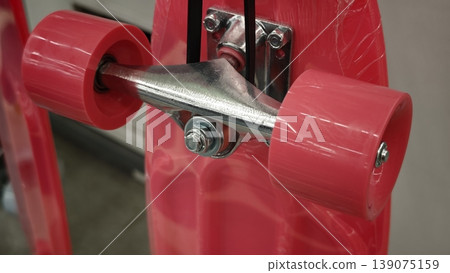 Skateboard with pink wheels and metal truck displayed in a store Skateboard with pink wheels and metal truck displayed in a store 139075159