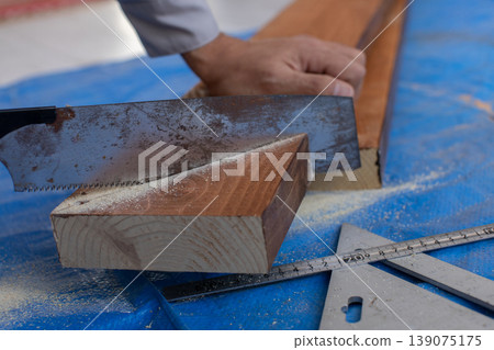 A man using a saw A man using a saw 139075175
