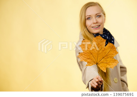 Woman holding orange autumn leaf Woman holding orange autumn leaf 139075691
