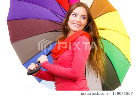 Woman standing under multicolored umbrella Woman standing under multicolored umbrella 139075867