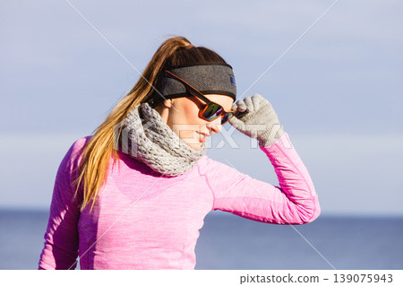 Woman resting after doing sports outdoors on cold day Woman resting after doing sports outdoors on cold day 139075943