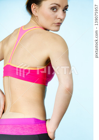 Woman with medical kinesio taping on back Woman with medical kinesio taping on back 139075957