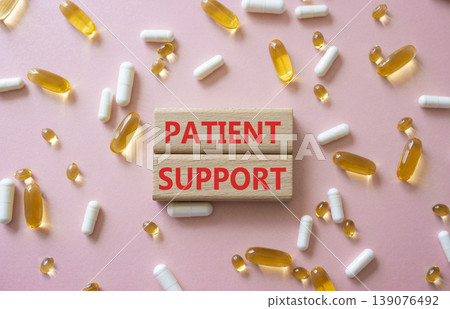 Patient Support symbol. Concept word Patient Support on wooden blocks. Beautiful pink background with pills. Medicine and Patient Support. Copy space Patient Support symbol. Concept word Patient Support on wooden blocks. Beautiful pink background with pills. Medicine and Patient Support. Copy space 139076492
