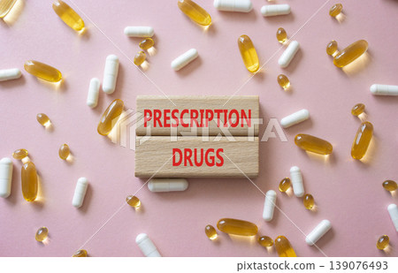 Prescription drugs symbol. Concept word Prescription drugs on wooden blocks. Beautiful pink background with pills. Medicine and Prescription drugs. Copy space Prescription drugs symbol. Concept word Prescription drugs on wooden blocks. Beautiful pink background with pills. Medicine and Prescription drugs. Copy space 139076493